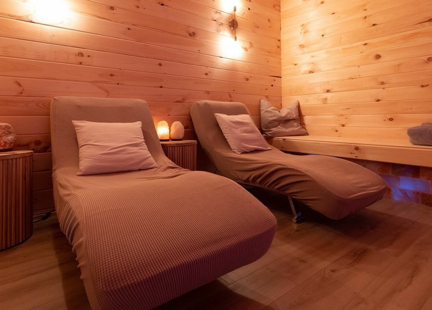 Relaxing lounge chairs in Lifted Lash Lounge and Wellness Spa, Clinton, Ontario, CA with warm ambient lighting.