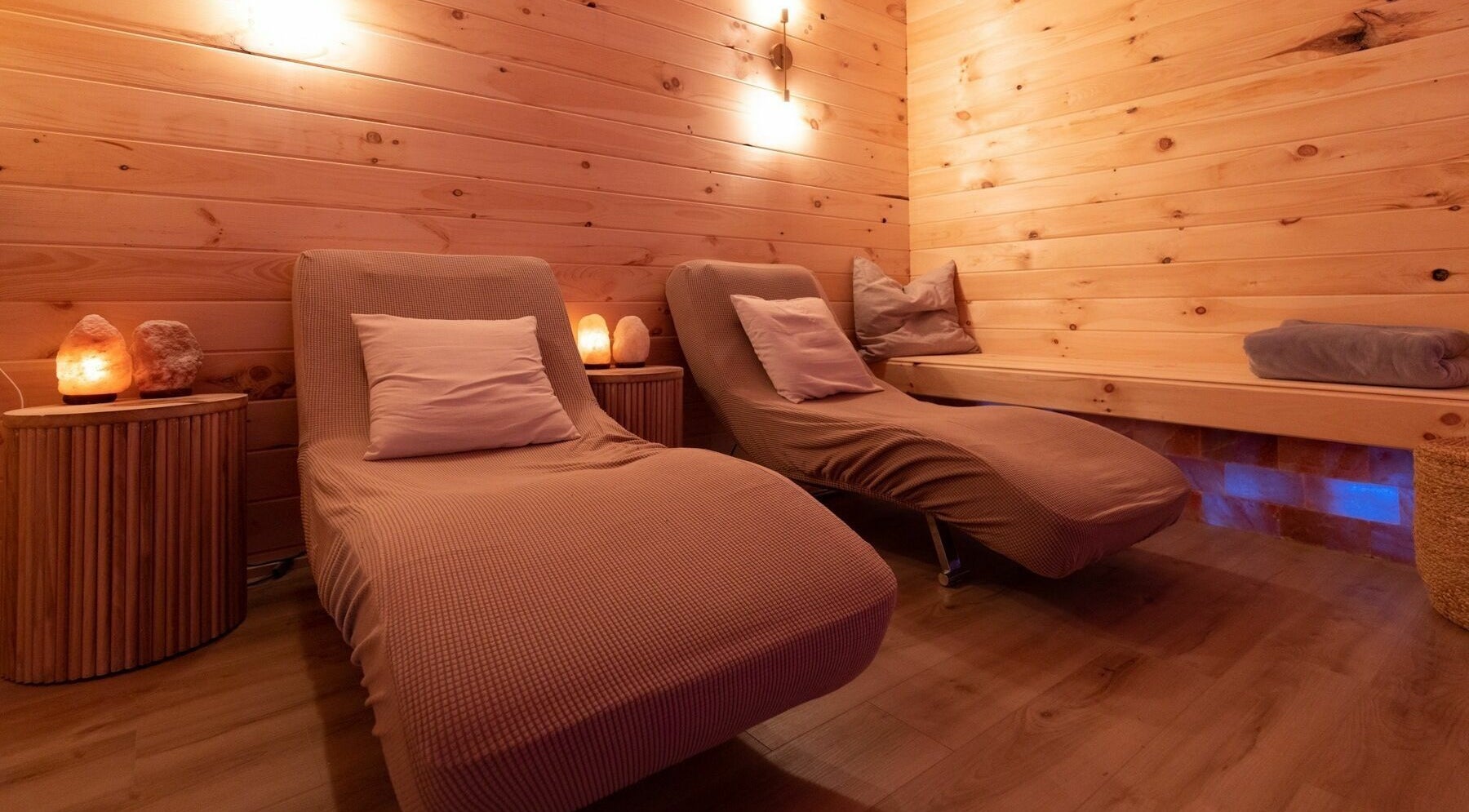 Relaxing lounge chairs in Lifted Lash Lounge and Wellness Spa, Clinton, Ontario, CA with warm ambient lighting.