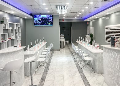 Modern interior of Epic Nail Bar, Orleans, Massachusetts, US with sleek nail stations and white decor.