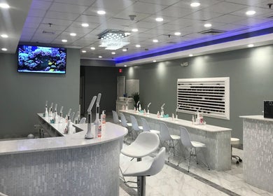 Modern interior of Epic Nail Bar in Orleans, Massachusetts, US featuring elegant white decor and nail stations.