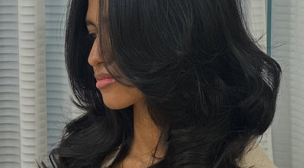 Stylish brunette hairstyle at Gloss Salon, Malé, Male, MV showcasing elegant glossy curls.
