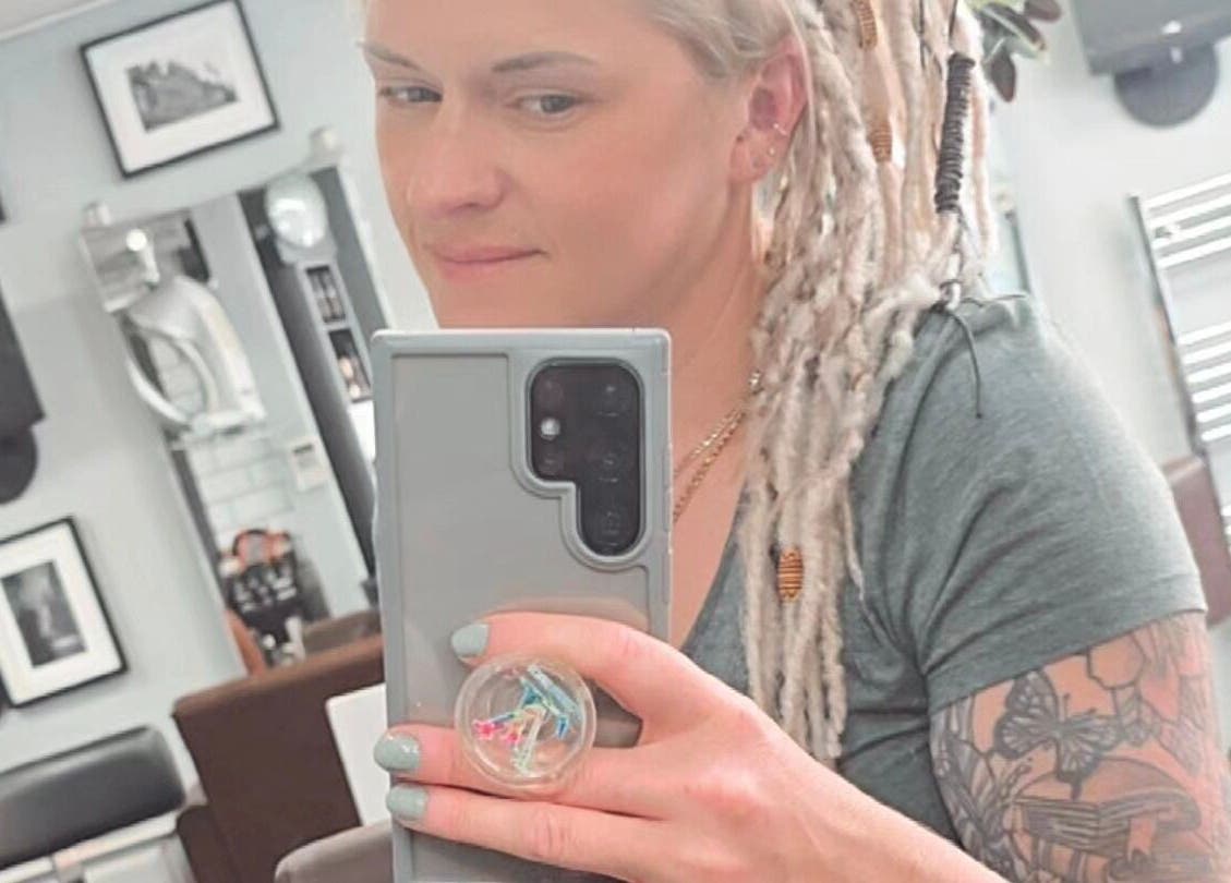 Customer at Alice Woolf salon in Gloucester, England taking a selfie in the salon mirror.