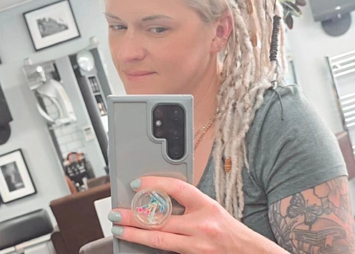 Customer at Alice Woolf salon in Gloucester, England taking a selfie in the salon mirror.