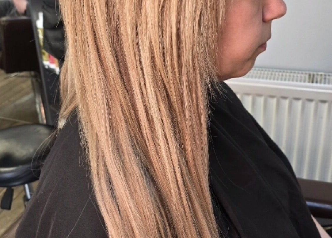 Expert hair styling at Alice Woolf, Gloucester, England, GB showcasing elegant blonde extensions.