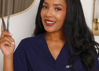 A beauty professional at The Beauty Chambers, Birmingham, England, GB, showcasing precision tweezers.