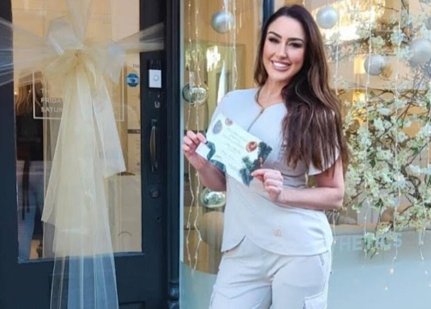 Staff member welcomes guests at Kylie Aesthetics, Christchurch, GB, showcasing vibrant atmosphere.