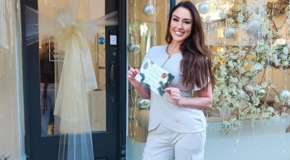 Staff member welcomes guests at Kylie Aesthetics, Christchurch, GB, showcasing vibrant atmosphere.