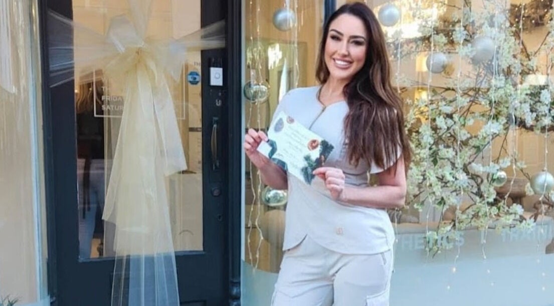 Staff member welcomes guests at Kylie Aesthetics, Christchurch, GB, showcasing vibrant atmosphere.