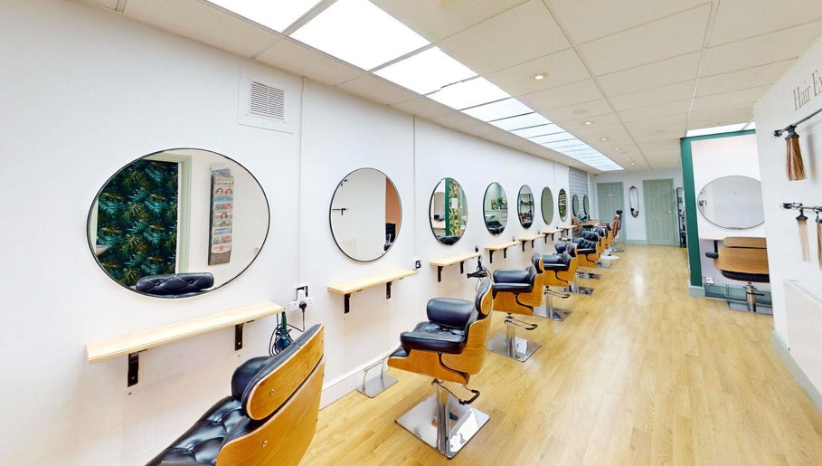 Modern salon chairs and mirrors at Auburn Hair & Beauty, Barnham, England, GB, showcasing a sleek design.