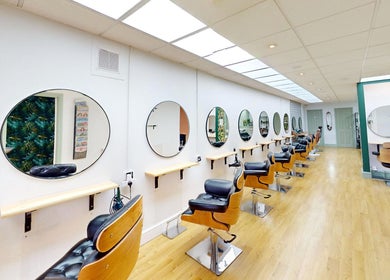 Modern salon chairs and mirrors at Auburn Hair & Beauty, Barnham, England, GB, showcasing a sleek design.