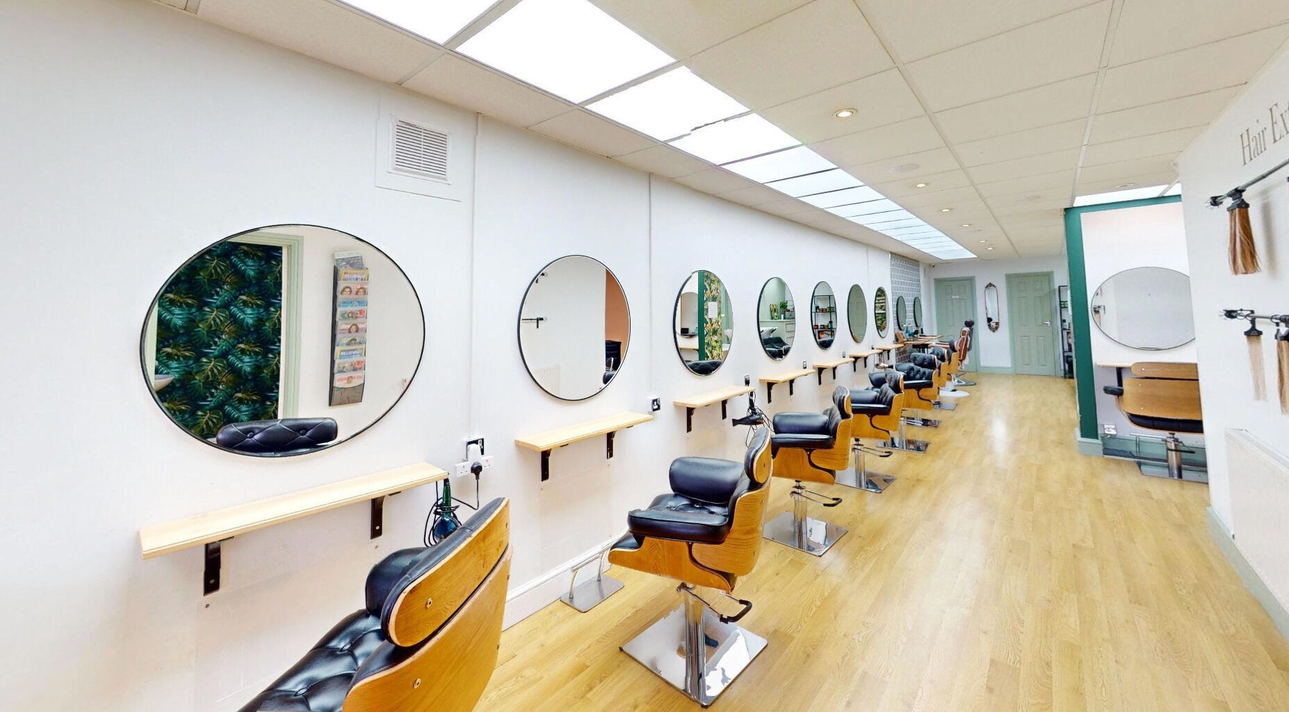 Modern salon chairs and mirrors at Auburn Hair & Beauty, Barnham, England, GB, showcasing a sleek design.