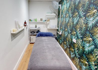 Relaxing beauty treatment room at Auburn Hair & Beauty, Barnham, England, GB with tropical leaf wallpaper.