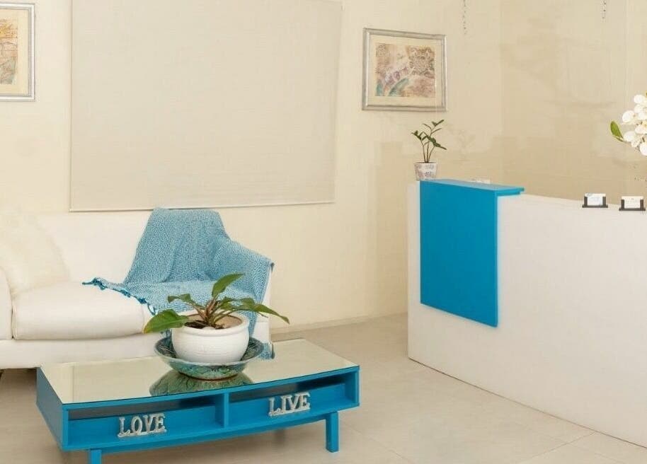 Ki West Spa's chic reception area in Bridgetown, Saint Michael, BB exudes comfort with a white sofa, blue accents.