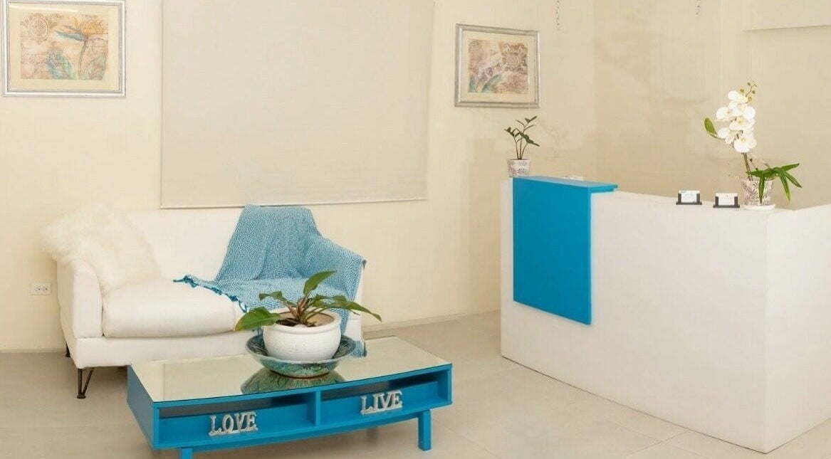 Ki West Spa's chic reception area in Bridgetown, Saint Michael, BB exudes comfort with a white sofa, blue accents.