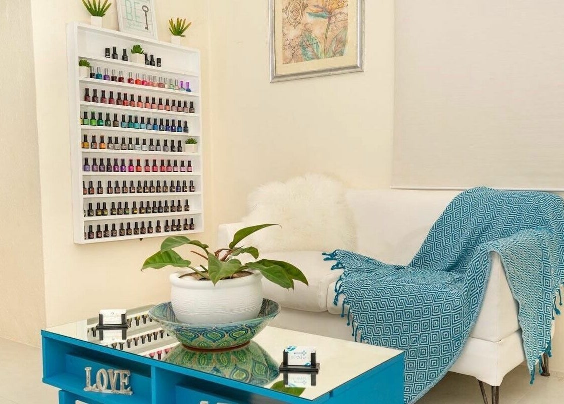 Relaxing spa lounge at Ki West Spa, Bridgetown, Saint Michael, BB with cozy seating and vibrant nail polish display.