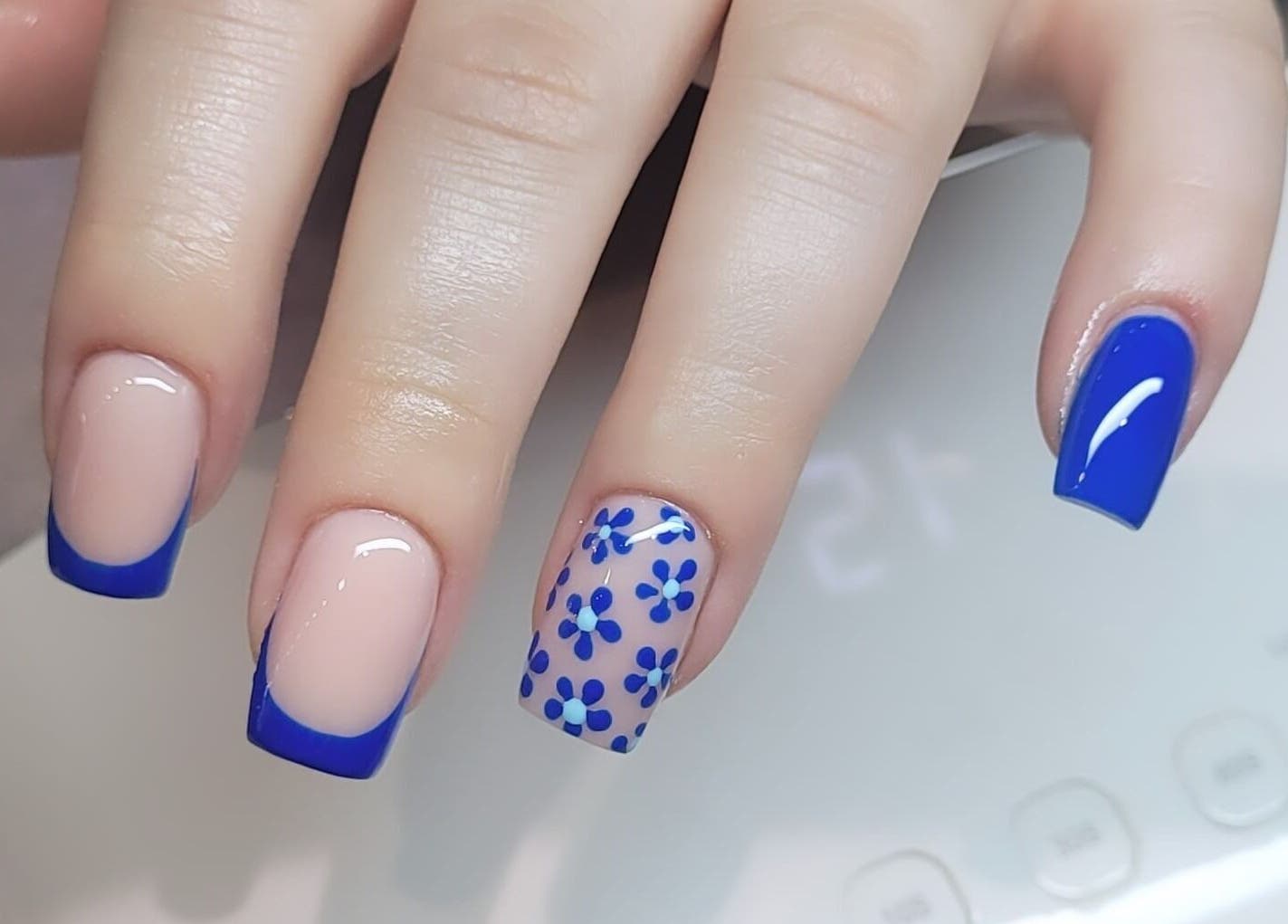 Elegant floral blue nail art at Tina Jane, Urmston, England, GB. Perfect for a chic style.