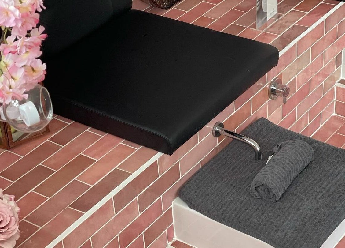 Chic spa seating with pink floral decor at Polished, Torquay, England, GB. Elegance in wellness.