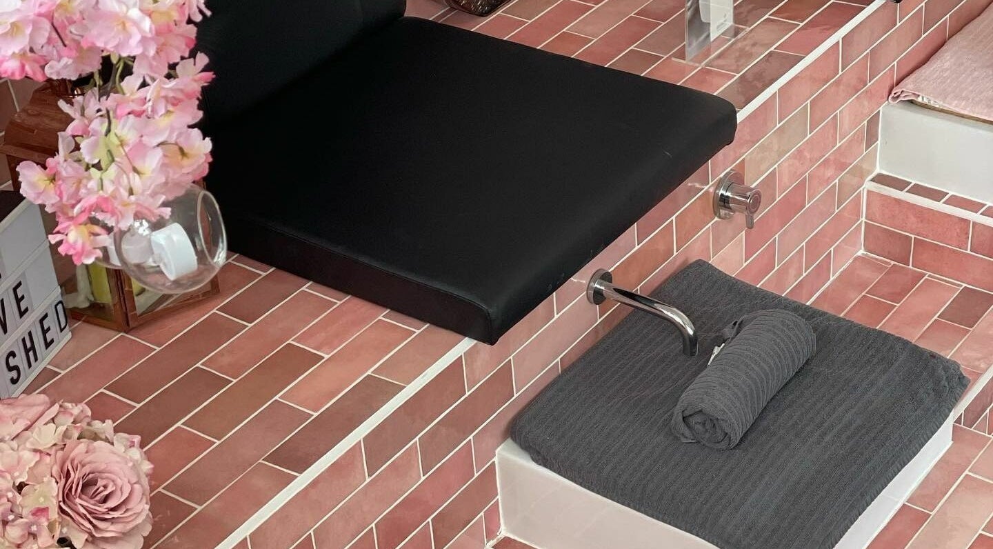 Chic spa seating with pink floral decor at Polished, Torquay, England, GB. Elegance in wellness.