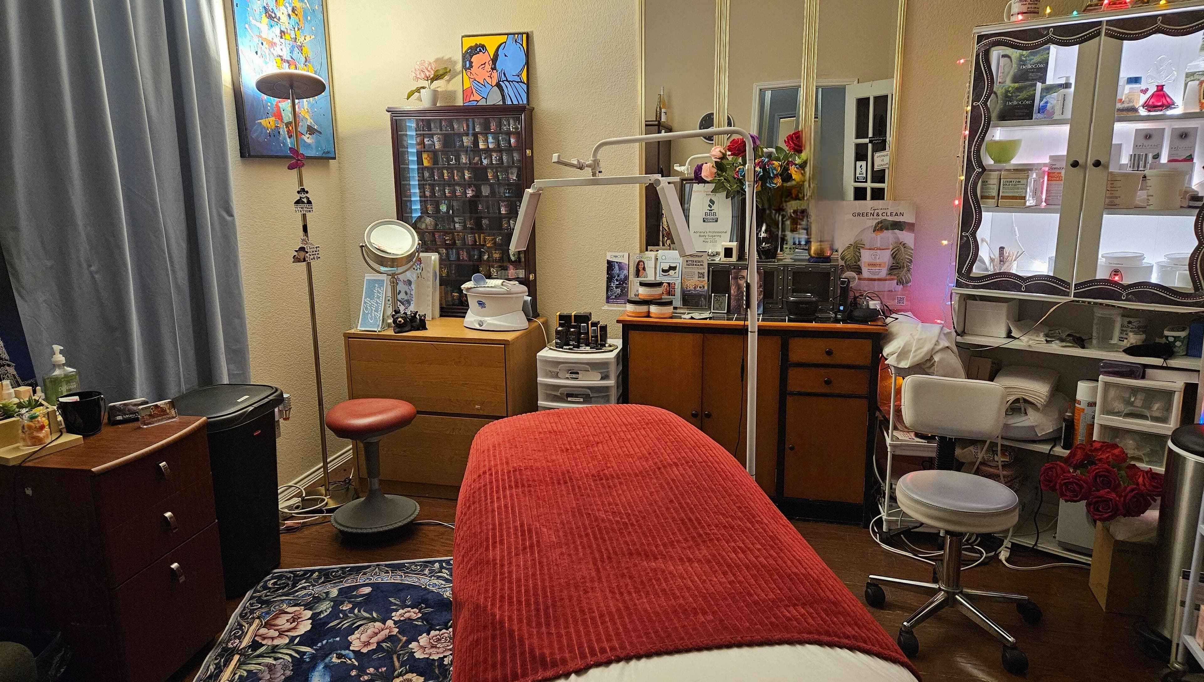 Cozy wellness room at Adriana's Professional Body Sugaring, Keller, Texas. Inviting environment with red accent.