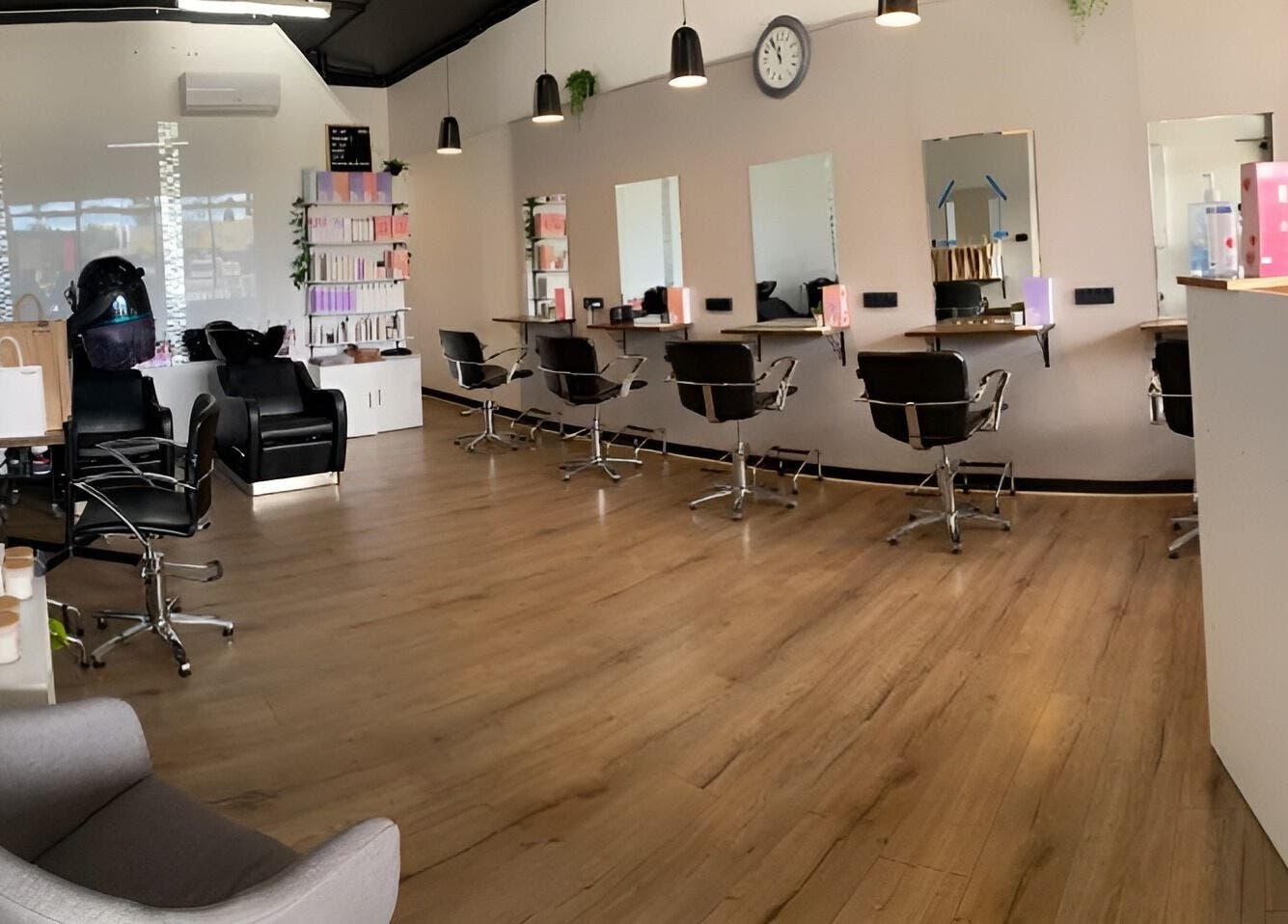 Modern salon at Envious Hair And Beauty, Figtree, New South Wales, AU. Sleek chairs and mirrors line the wall.
