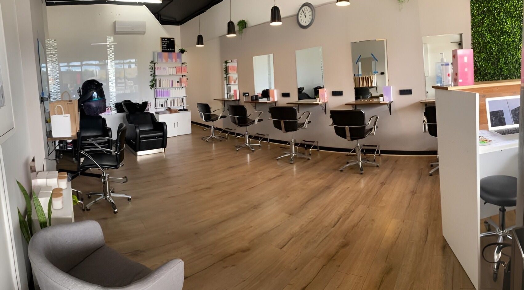 Modern salon at Envious Hair And Beauty, Figtree, New South Wales, AU. Sleek chairs and mirrors line the wall.