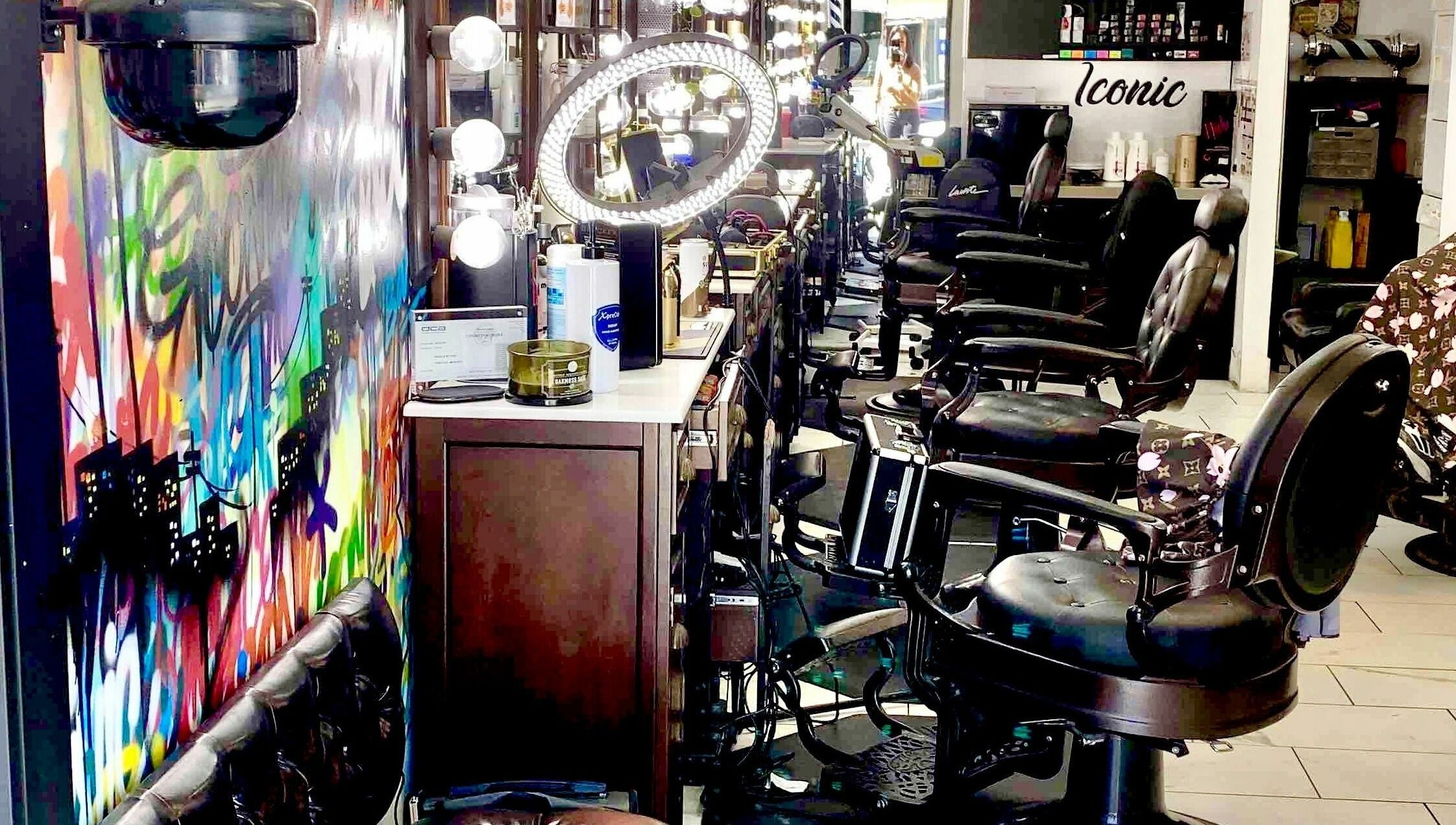 Colorful interior of Iconic Barbershop West Hollywood, showcasing modern chairs and art in West Hollywood, California, US.