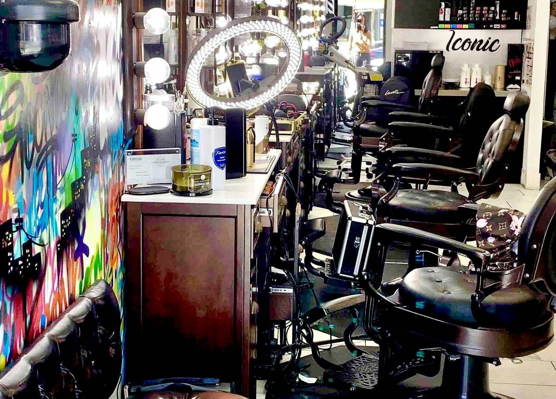 Colorful interior of Iconic Barbershop West Hollywood, showcasing modern chairs and art in West Hollywood, California, US.