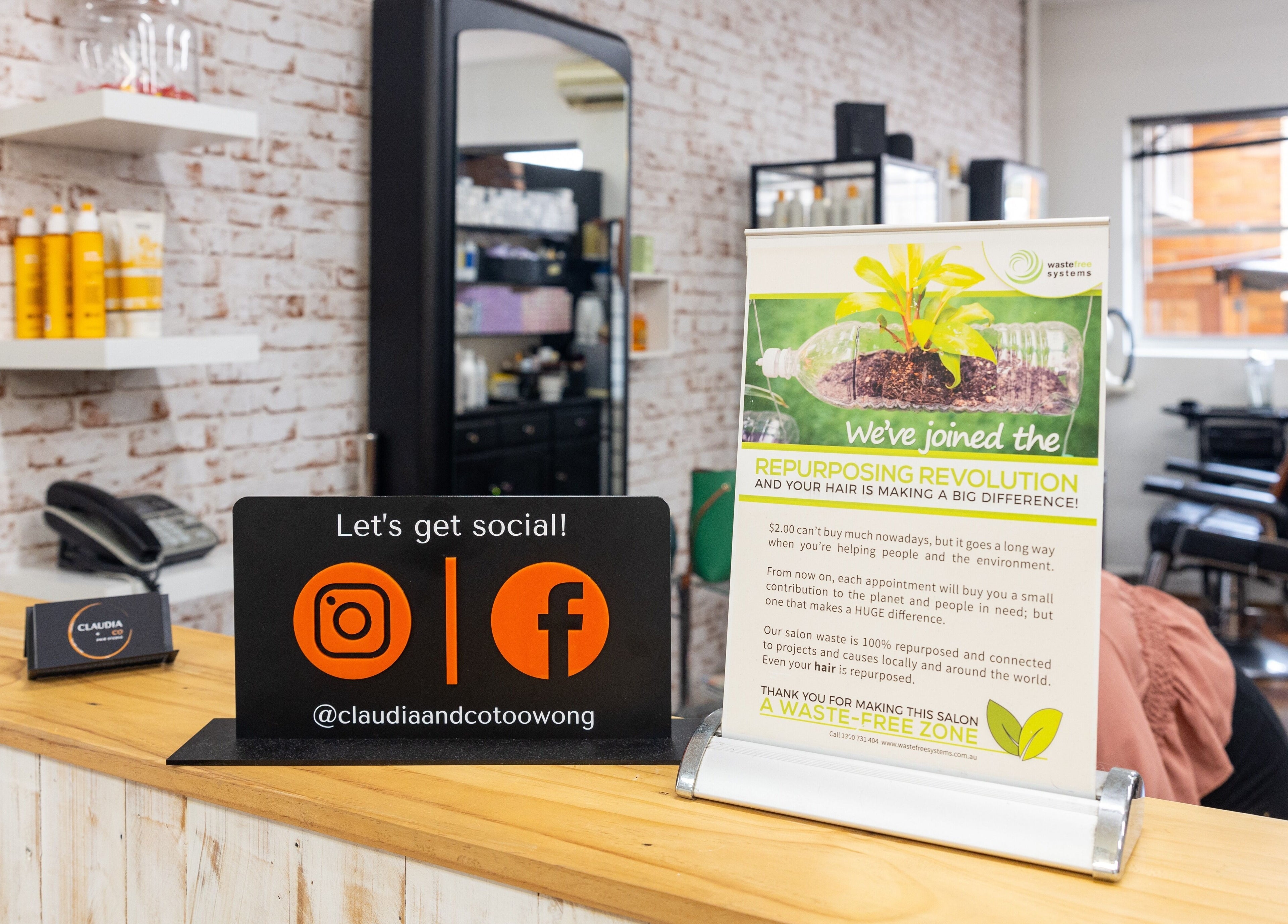 Reception desk with eco-signage at Claudia and Co, Toowong, Queensland, AU promoting sustainability.