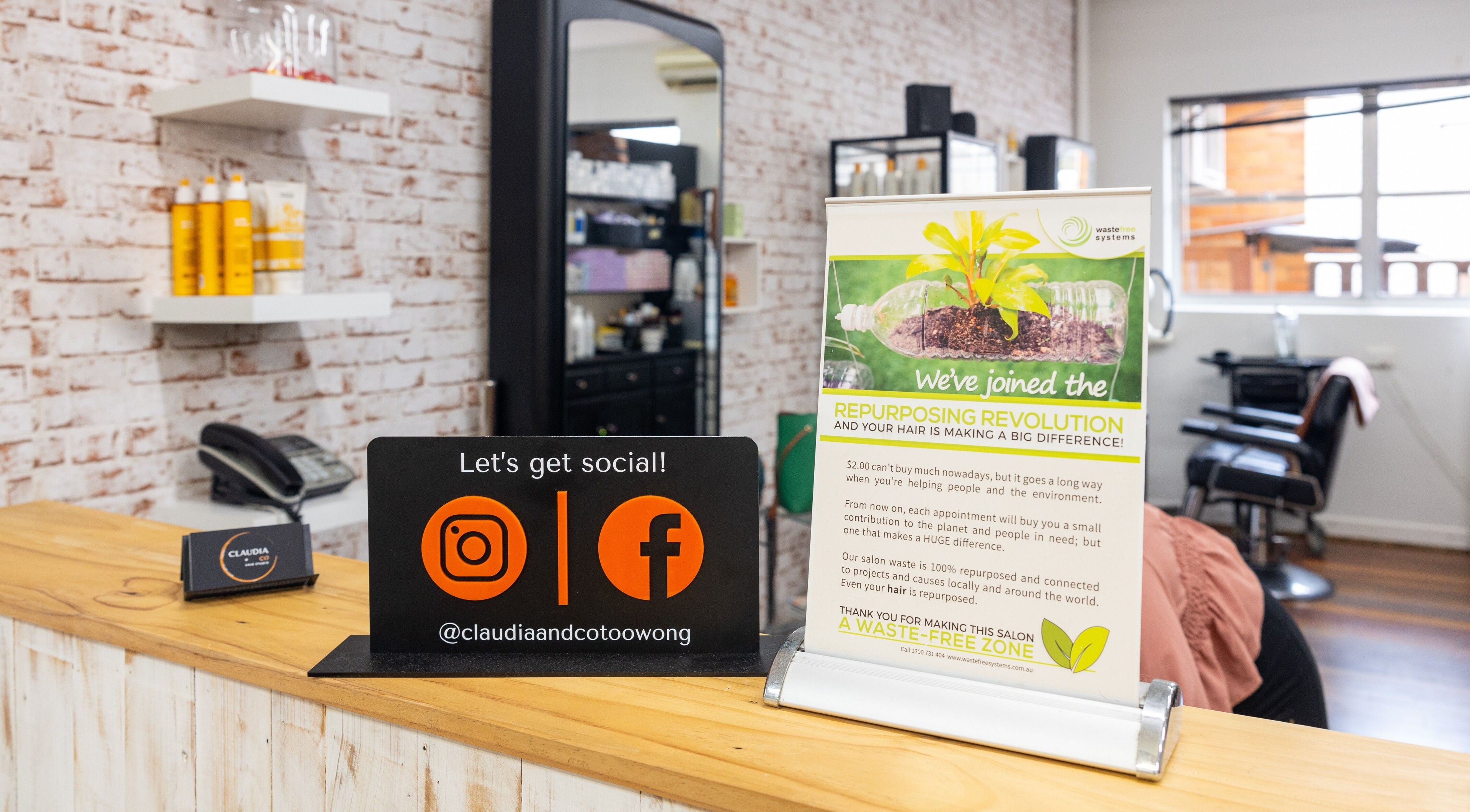 Reception desk with eco-signage at Claudia and Co, Toowong, Queensland, AU promoting sustainability.