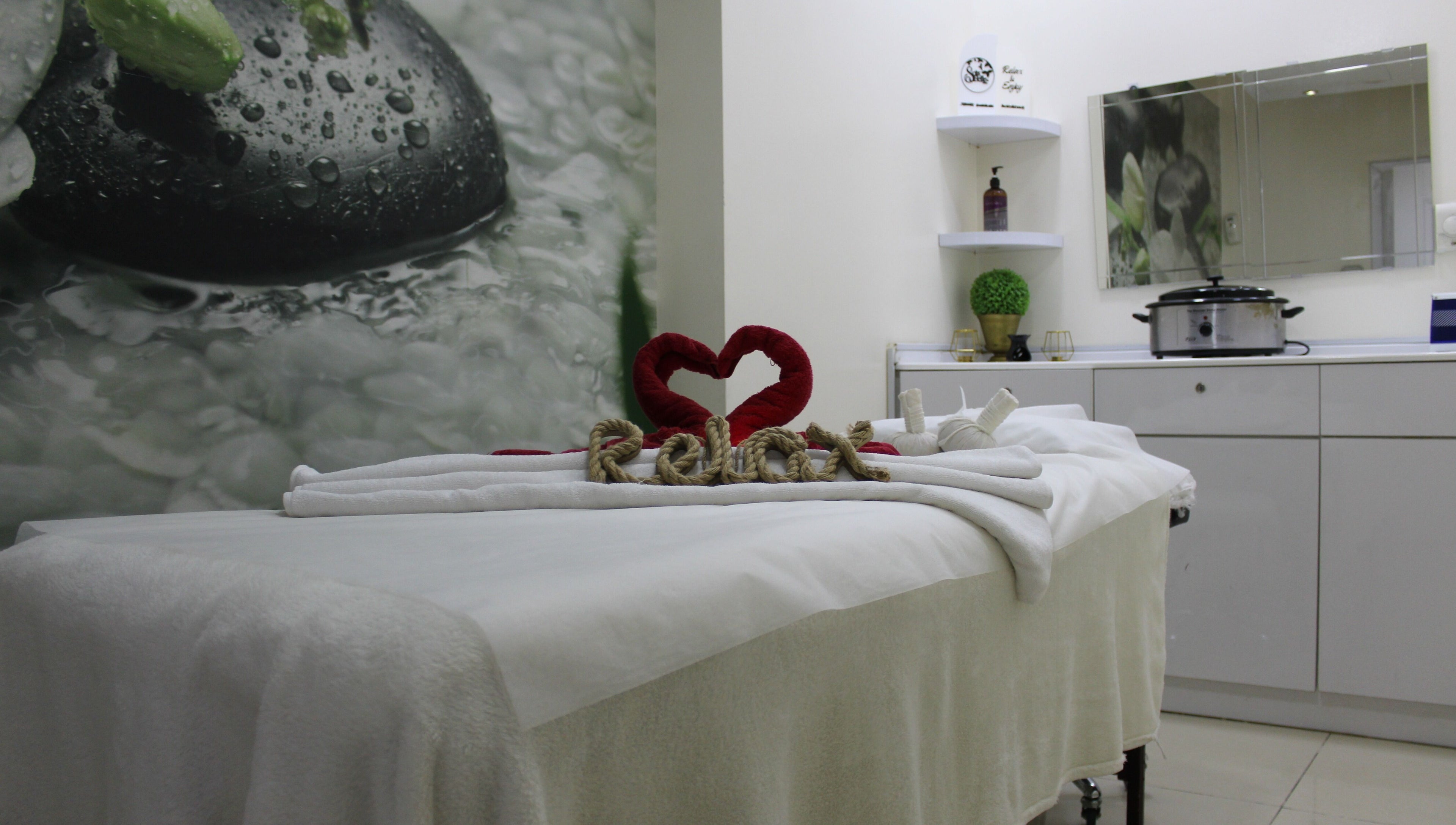 Relaxing massage room at Sois Belle Salon, Abu Dhabi, AE. Cozy spa setting with heart decor.