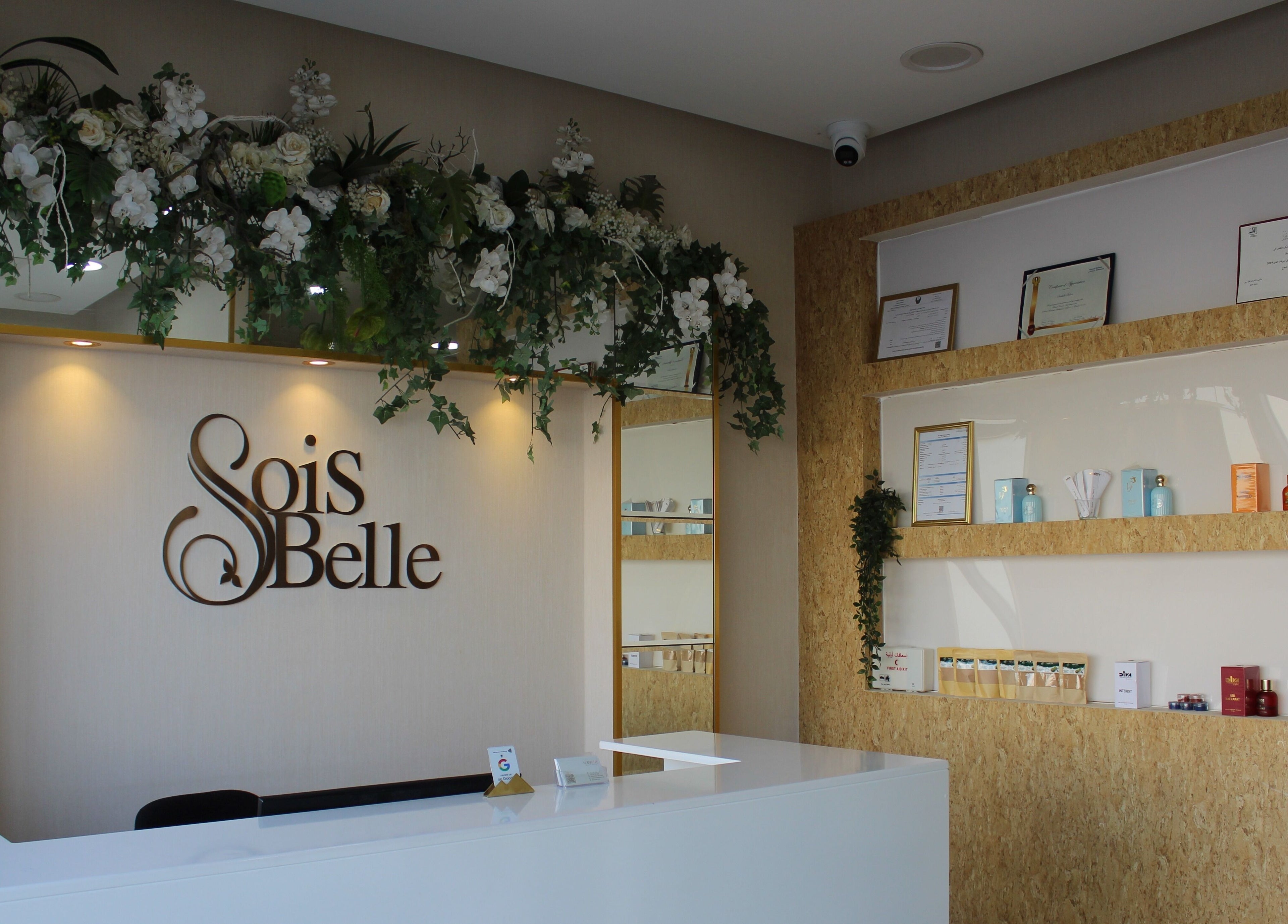 Reception at Sois Belle Salon, Abu Dhabi, AE with floral decor and beauty products displayed on shelves.