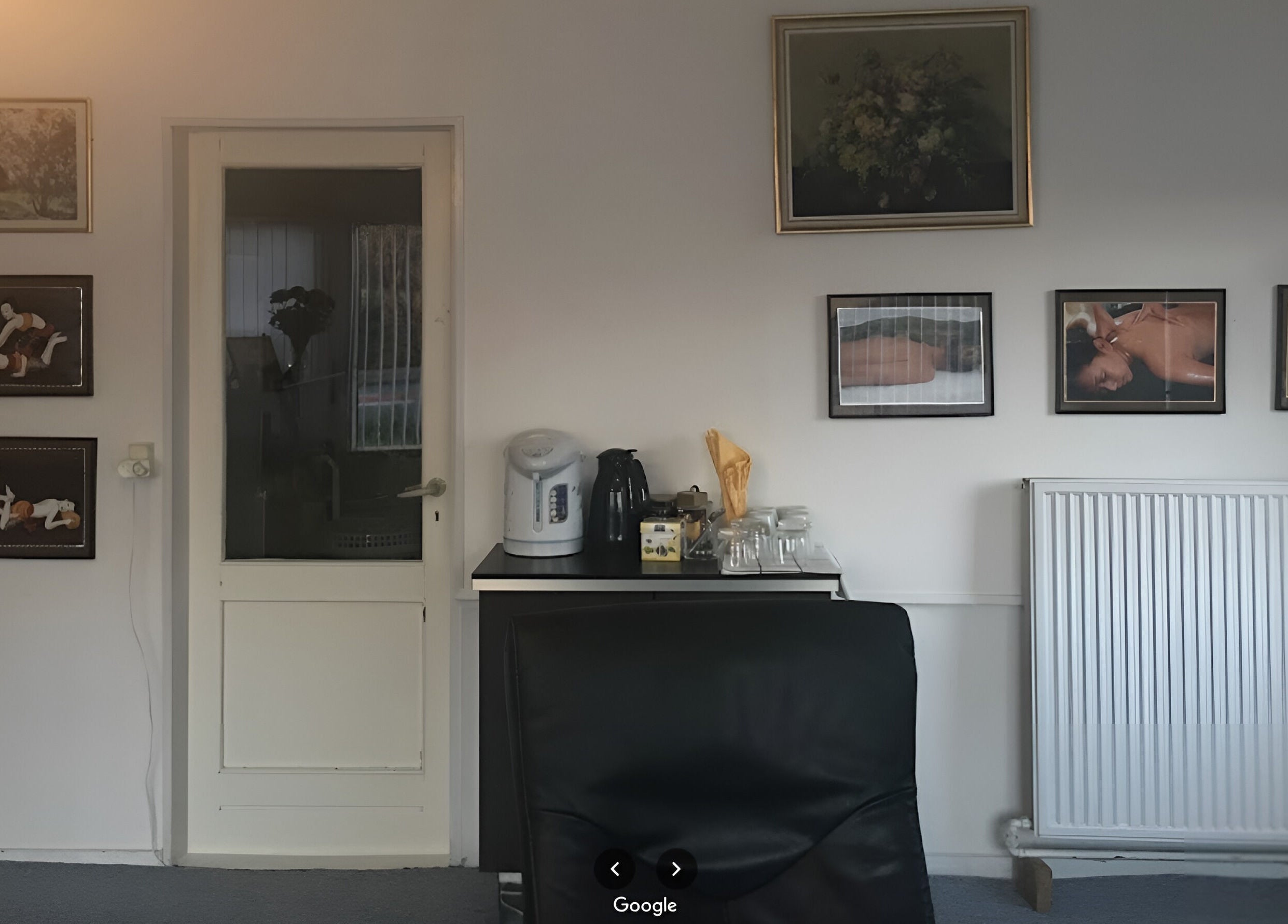 Receptionen hos Patty Wellness Thai Massage i Skanderborg, DK, med kunst på væggene og en kaffestation.