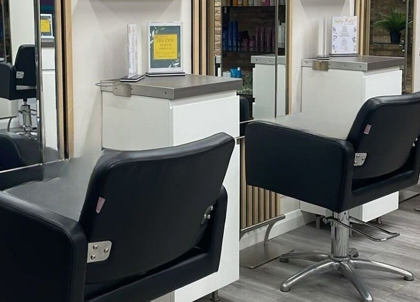 Sleek salon stations at Clip’so Ely in Ely, England, GB, showcasing modern black styling chairs and mirrors.
