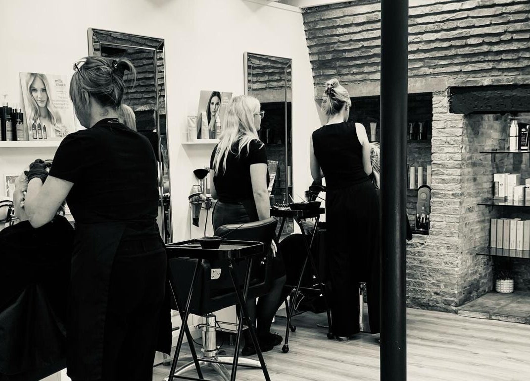 Professional hairstylists working at Clip’so Ely salon in Ely, England, GB, featuring modern decor and beauty products.