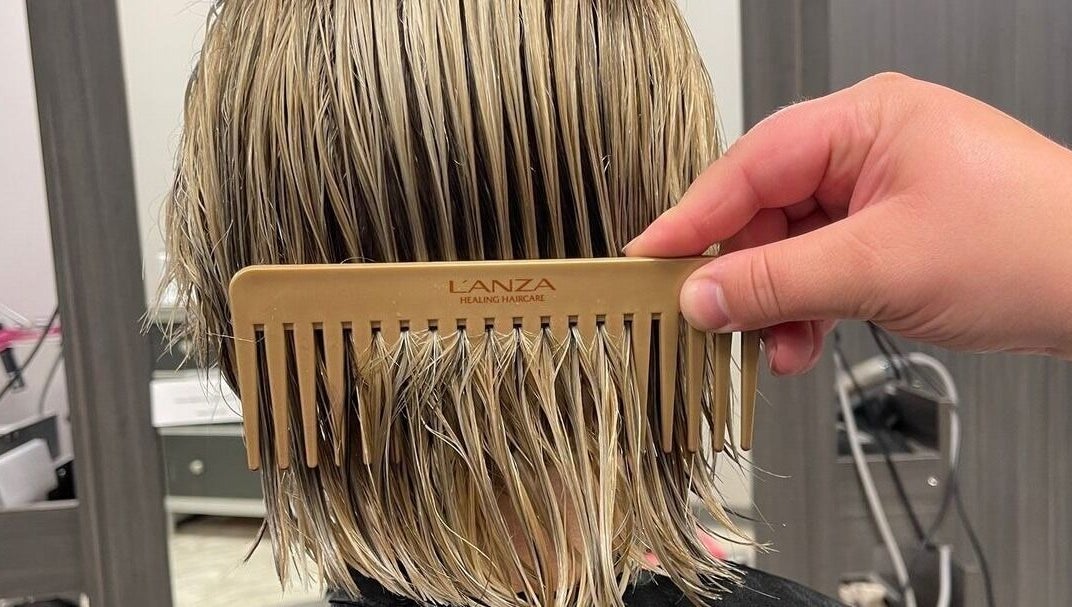 Expert hairstyling at Cut of Class, Carman, Manitoba, CA. Close-up of hair being combed.
