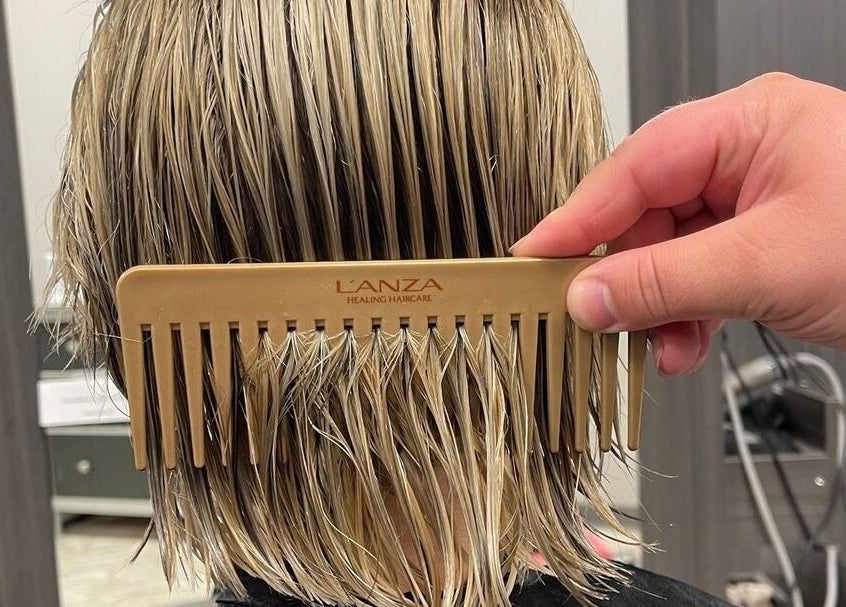Expert hairstyling at Cut of Class, Carman, Manitoba, CA. Close-up of hair being combed.