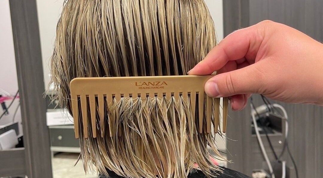 Expert hairstyling at Cut of Class, Carman, Manitoba, CA. Close-up of hair being combed.