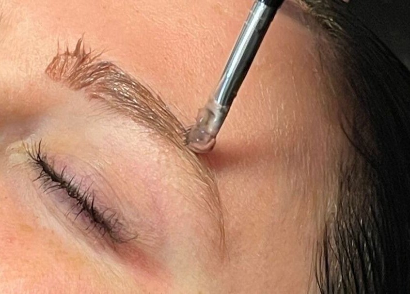 Eyebrow shaping at Cut of Class, Carman, Manitoba, CA. Close-up of precise grooming with a brush tool.