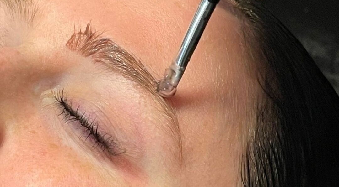 Eyebrow shaping at Cut of Class, Carman, Manitoba, CA. Close-up of precise grooming with a brush tool.