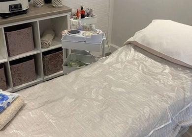 Relaxing treatment room at The Beauty House, Thurso, Scotland, GB with a soothing spa bed and organized shelves.
