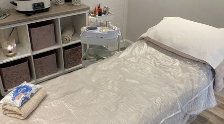 Relaxing treatment room at The Beauty House, Thurso, Scotland, GB with a soothing spa bed and organized shelves.