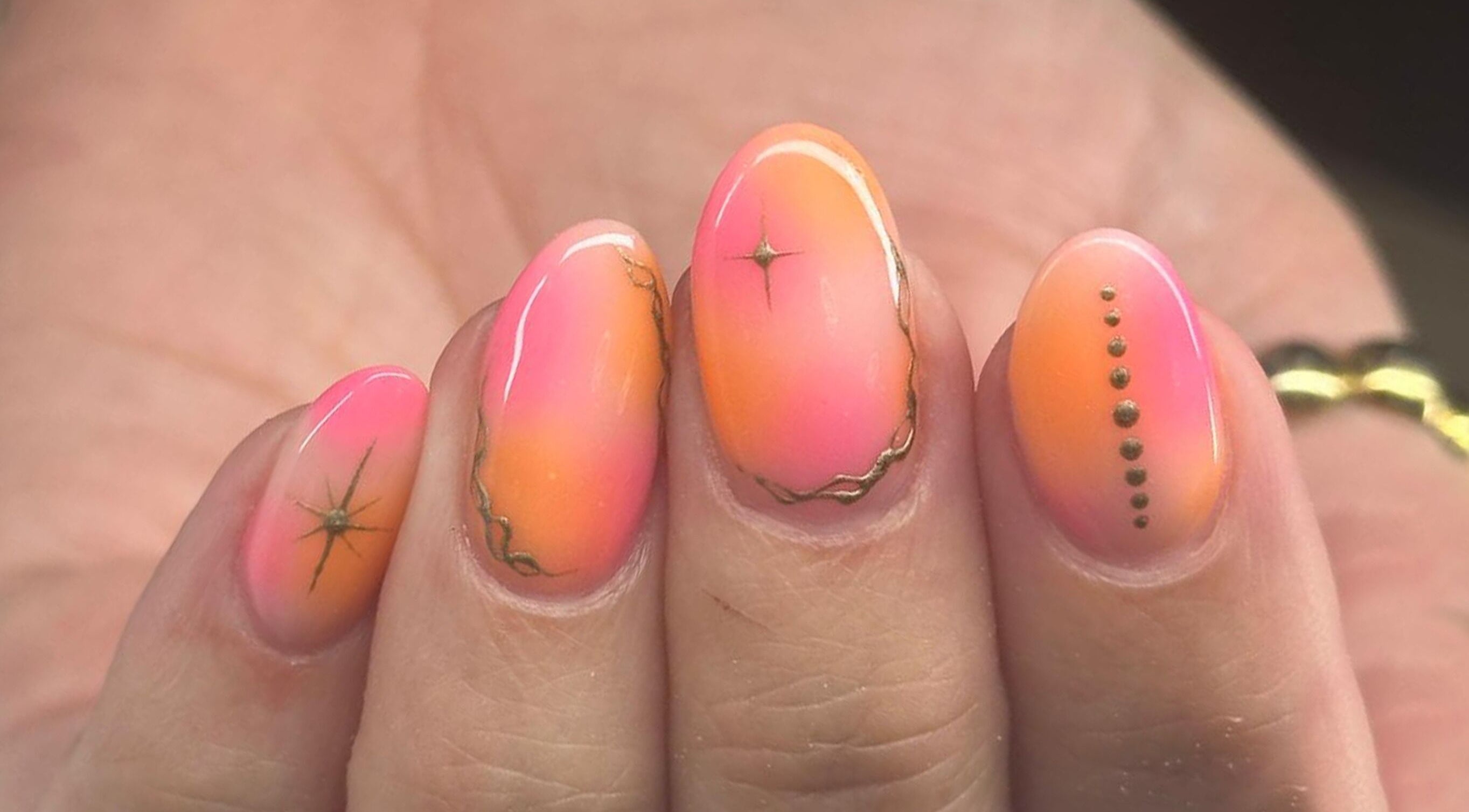 Vibrant pink and orange nail art with intricate designs at Classic Beauty Boutique, Bournemouth, England, GB.