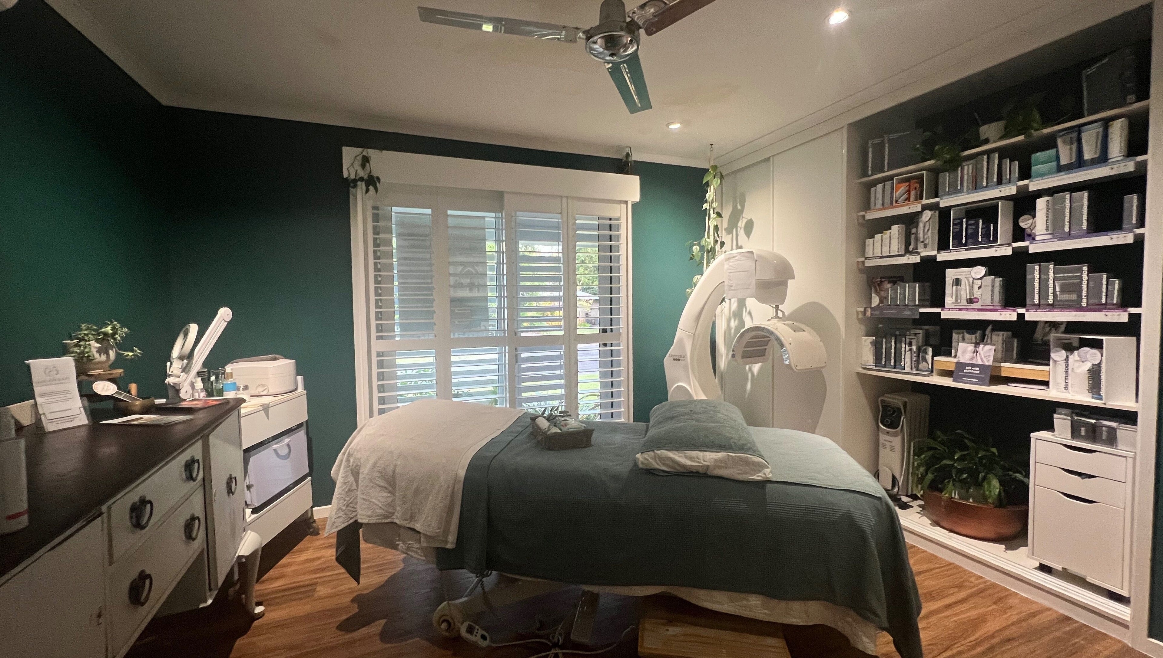 Tranquil spa room at Skin Therapy at Ocean Shores, New South Wales, AU with teal walls and cozy bed.