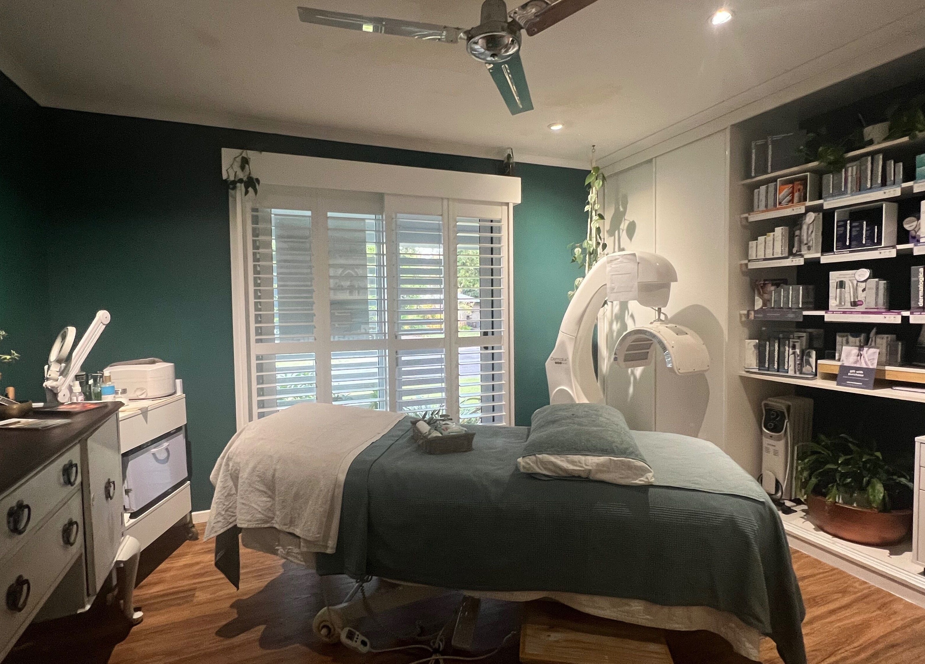 Tranquil spa room at Skin Therapy at Ocean Shores, New South Wales, AU with teal walls and cozy bed.