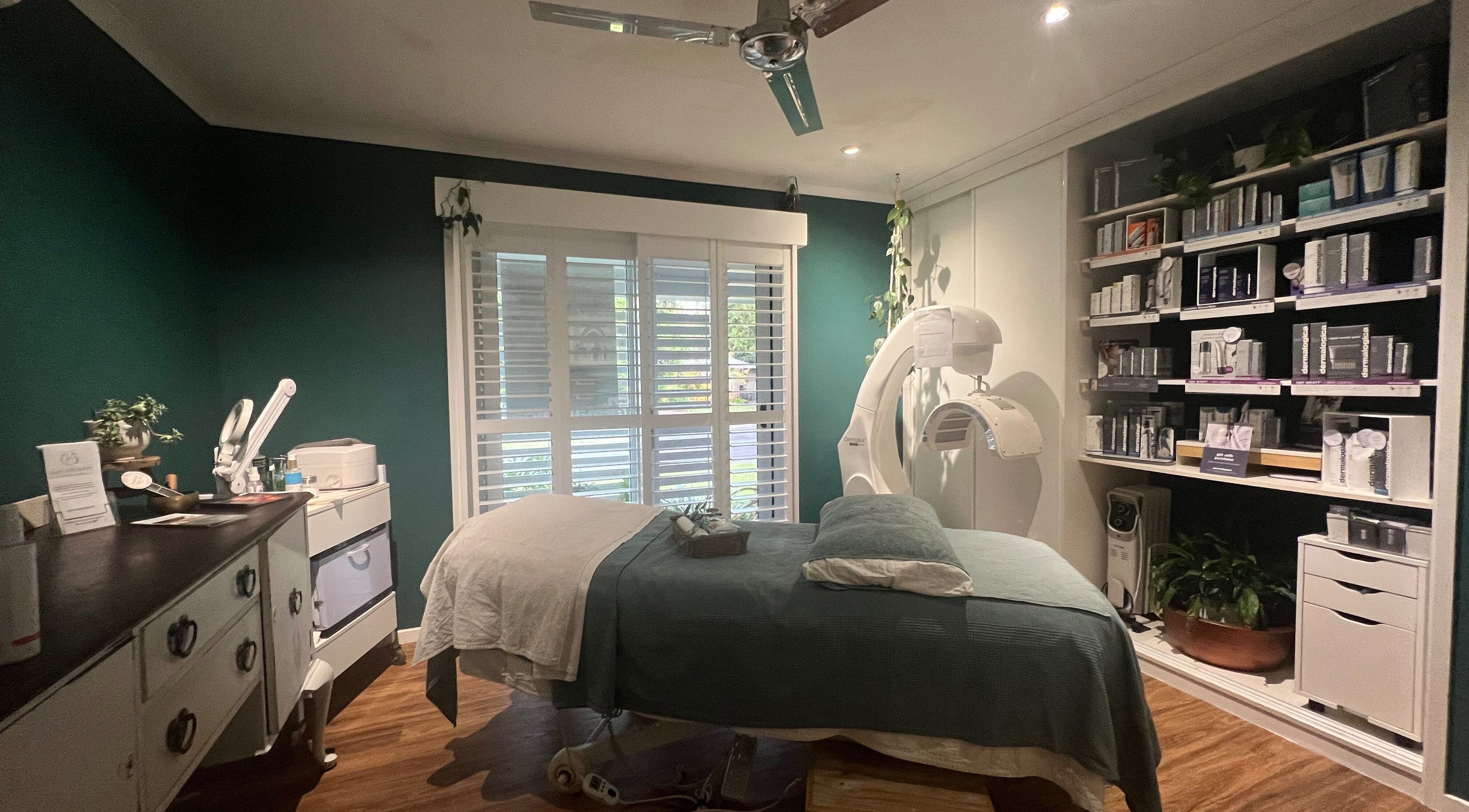 Tranquil spa room at Skin Therapy at Ocean Shores, New South Wales, AU with teal walls and cozy bed.