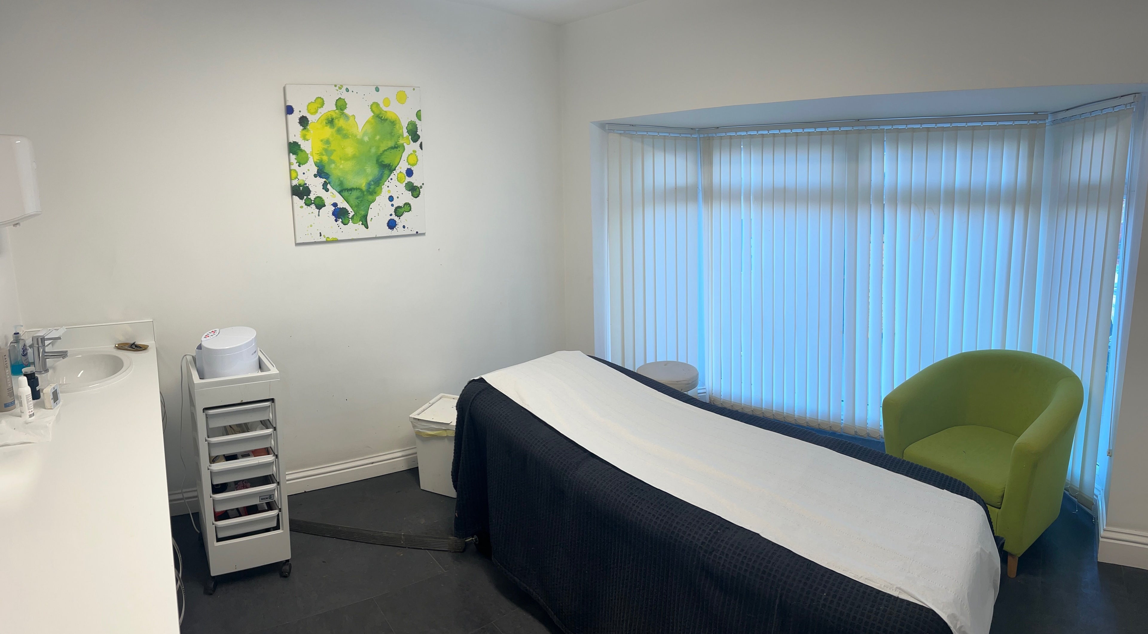 Relaxing spa room at Truly Madly Nails & Beauty, Maltby, England, GB with massage bed and green chair.