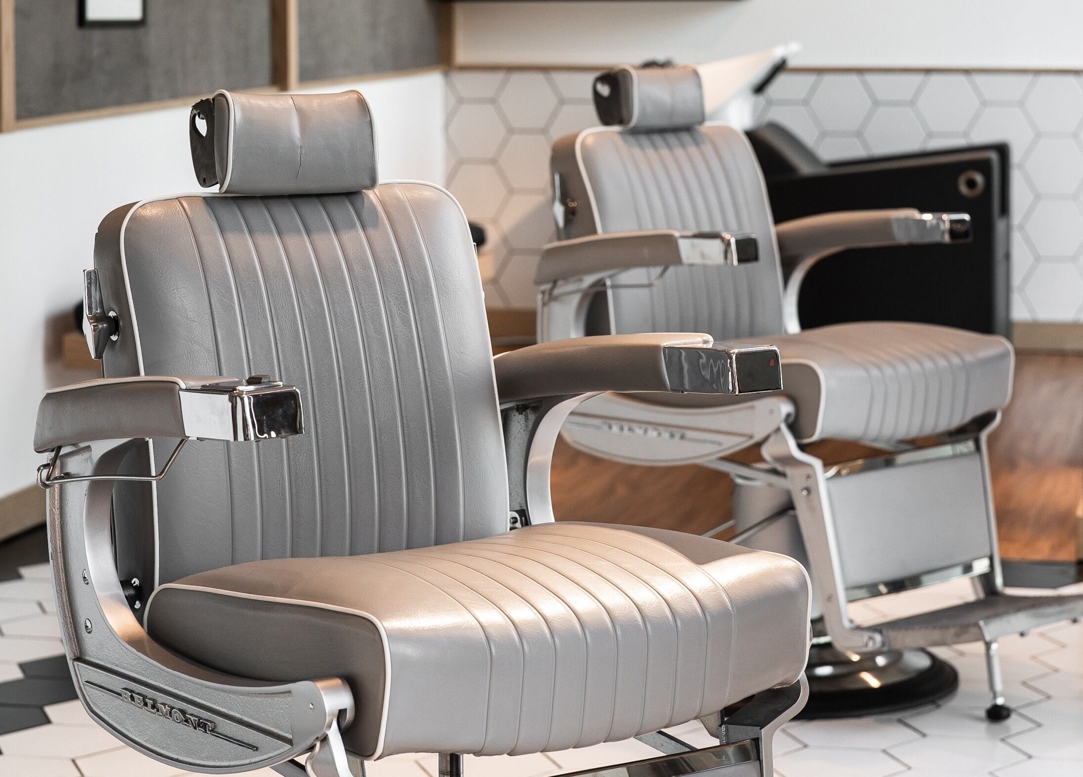 Modern barber chairs at Akin Barber and Shop, 25 Hours Hotel, Dubai, Dubai, AE, offering sleek comfort.