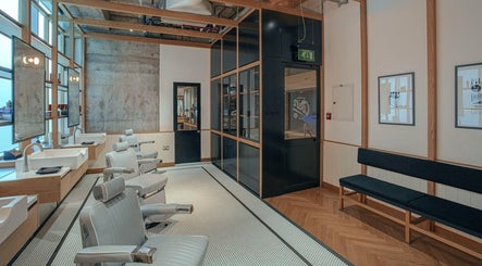 Modern interior of Akin Barber & Shop Burj Al Salam, Dubai, AE, featuring stylish barber chairs and mirrors.