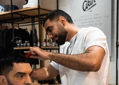 Barber at Akin Barber & Shop Burj Al Salam in Dubai, AE, expertly styling a client's hair.