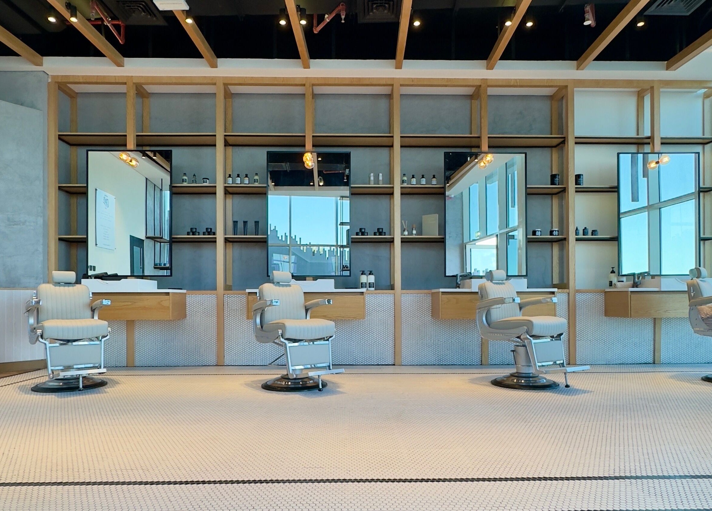Interior of Akin Barber & Shop AbuDhabi By The Creek in Abu Dhabi, featuring modern barber chairs and sleek decor.